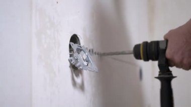 Puncher Kullanan Bir İnşaatçı Bir Çıkış Kurmak için Beton Duvarda Delik Açar