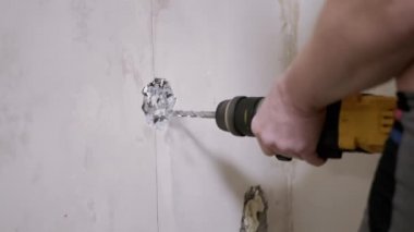 Puncher Kullanan Bir İnşaatçı Bir Çıkış Kurmak için Beton Duvarda Delik Açar.
