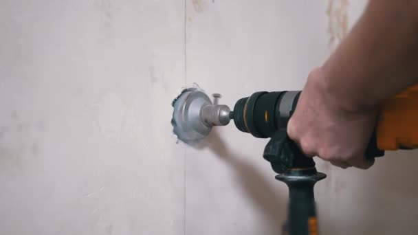 Constructor usando un perforador hace un agujero en una pared de hormigón para establecer un enchufe de alimentación — Vídeos de Stock