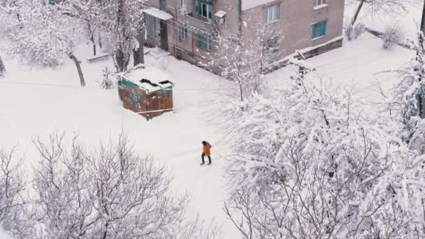 住宅用レンガ造りの家の雪に覆われたヤードにある古いラスティガレージ — ストック動画