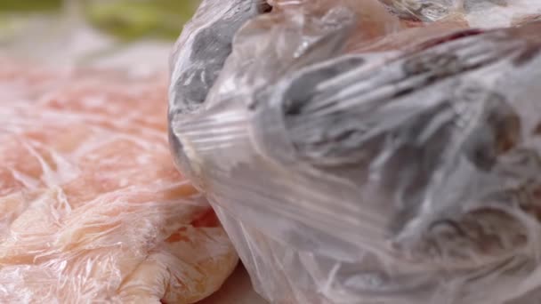 Размораживание замороженного сырого мяса и полуфабрикатов рыбы для приготовления пищи. Закрыть — стоковое видео