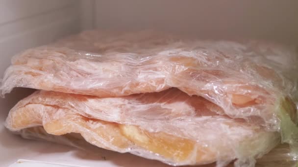 Frisches Fleisch in Klebefolie im Gefrierfach in Zeitlupe lagern und einfrieren — Stockvideo