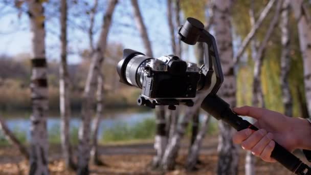 Фотограф настраивает камеру на штатив перед съемкой в природе. 4K, Close up — стоковое видео