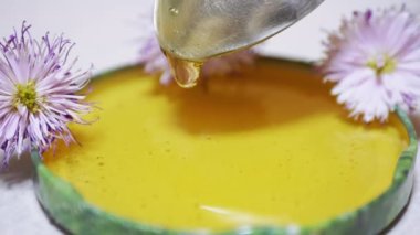 Şeffaf Bal bir kaşıktan bir Lid 'e dökülür, bir kâseye. Yakın plan. 4K