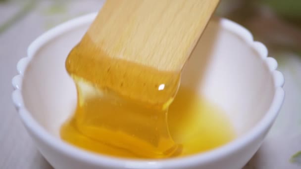 Mão Stirs com uma Espátula de Madeira, Ladle Yellow Thick Honey in a Bowl. Fechar — Vídeo de Stock