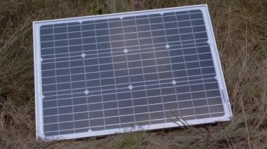 Bir adet portatif küçük fotovoltaik güneş paneli çimenlere yerleştirildi. Büyüt