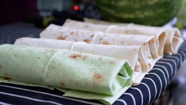 Disiapkan, Wrapped in a Pita Roll, Shawarma Lies on the Table in the Open Air. Perbesar — Stok Video