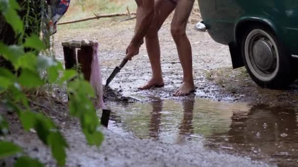 Human Digs een Storm Drain, een Trench, een Drainage in Wet Earth met een shovel. — Stockvideo