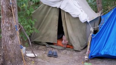 Çıplak Ayaklı Erkek Bacakları Doğadaki Açık Askeri Çadırdan dışarı bakıyor. Büyüt