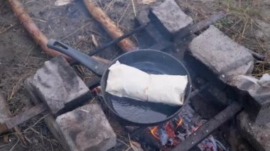Pita on Outdoor 'da paketlenmiş et Shawarma hazırlama, Pan' da yanan şenlik ateşi.