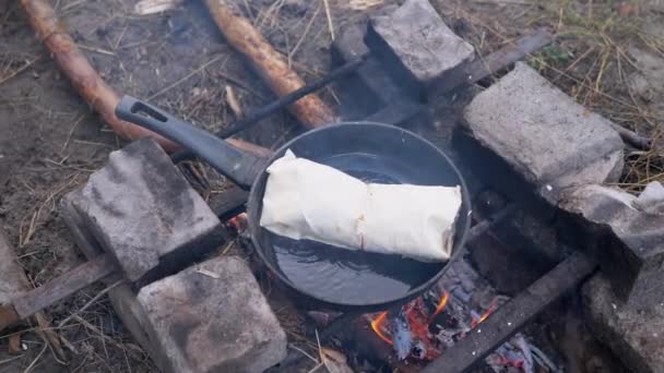 Zubereitung von Fleisch Shawarma Wrapped in Pita im Freien, brennendes Lagerfeuer, in Pfanne — Stockvideo