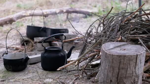 Prepared Firewood Lies on the Background of Cooking Food over a Fire in Pots — Stock Video