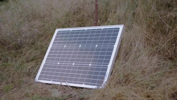Bir adet portatif küçük fotovoltaik güneş paneli çimenlere yerleştirildi. 4K — Stok video