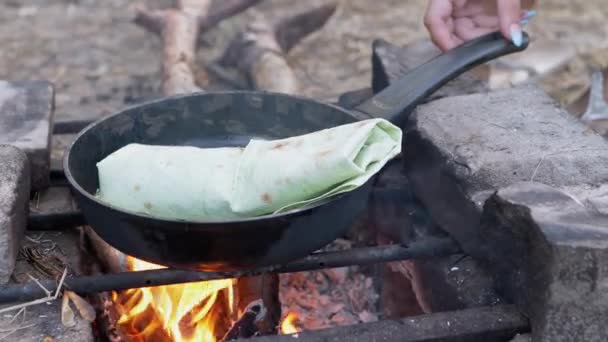 Kochen Fleisch Shawarma in Pita-Brot am offenen, brennenden Lagerfeuer, in Pfanne gewickelt. 4K — Stockvideo