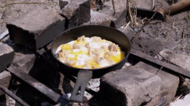 Şenlik ateşinde Çırpılmış Yumurta Kızartma Tavasında Hazırlık. Yavaş çekim