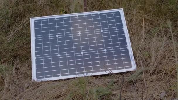 Ένας φορητός ηλιακός συλλέκτης φωτοβολταϊκών εγκαταστάθηκε στο γρασίδι. 4K — Αρχείο Βίντεο