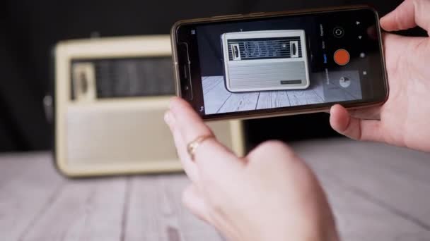 スマートフォンで古いヴィンテージのラジオ受信機の写真を撮る女性の手 — ストック動画