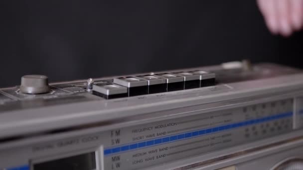 Kvinnelige fingre trykker knapper på en gammel kassettspiller i mørkt rom. – stockvideo