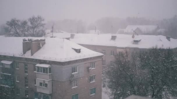 Sníh padá na střechy starých obytných budov ve dvoře. Zpomalený pohyb — Stock video