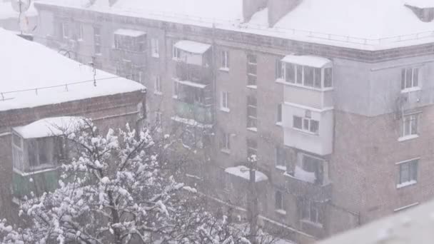 Snöfall Fallande på taken i gamla bostadsbyggnader på varvet. Långsamma rörelser — Stockvideo