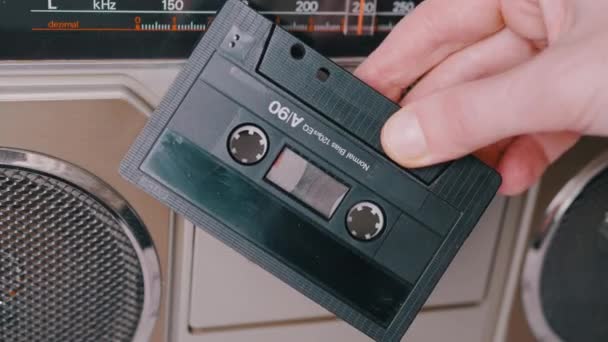 Weibliche Hand dreht eine alte Audio-Kassette aus den 90er Jahren neben einem Stereo-Tonbandgerät — Stockvideo