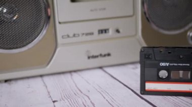 Kadın El, 90 'lı yıllardan kalma bir kaseti Stereo Teyp' in yanında tutuyor.