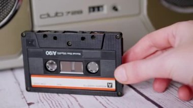 Kadın El, 90 'lı yıllardan kalma bir kaseti Stereo Teyp' in yanında tutuyor.