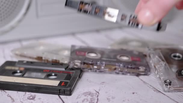 Female Hand met une vieille cassette audio noire classique sur la table. 4K. Gros plan — Video