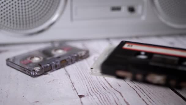 Female Hands Throwing an Old Black Audio Cassette on Table. Slow motion — Stock Video