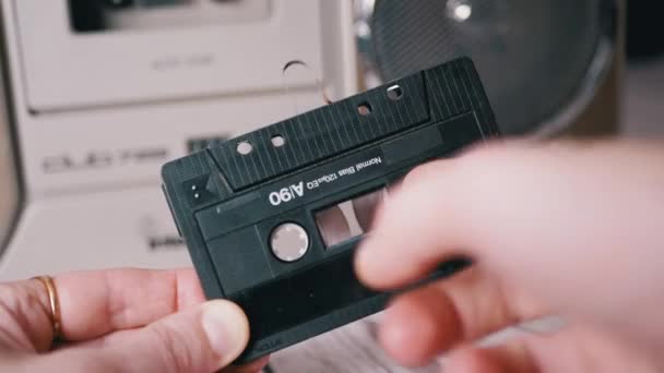 La hembra rebobina una cinta magnética con dedo en la antigua cassette de audio vintage — Vídeo de stock