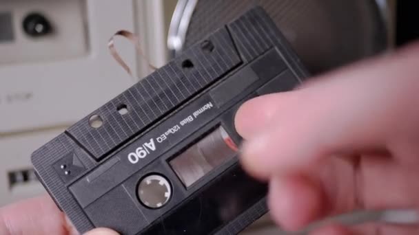 Feminino rebobina uma fita magnética com o dedo na velha cassete de áudio vintage — Vídeo de Stock