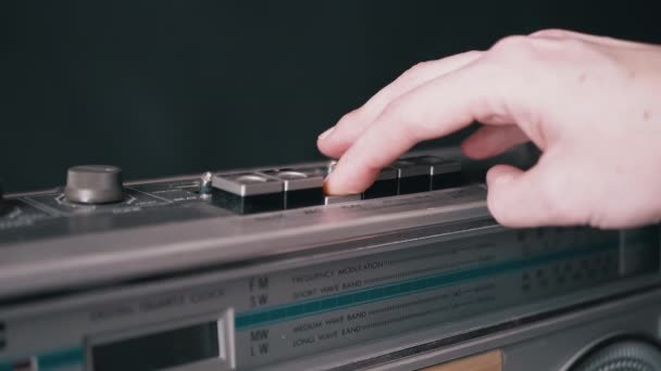 검은 방에 있는 오래 된 빈티지 테이프를 사용하여 버튼을 누르는 암컷 손가락 — 비디오