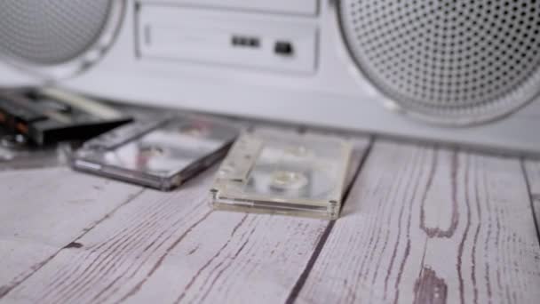 Vrouwelijke handen gooien veel oude audiocassettes op tafel. 4K. Sluiten. — Stockvideo