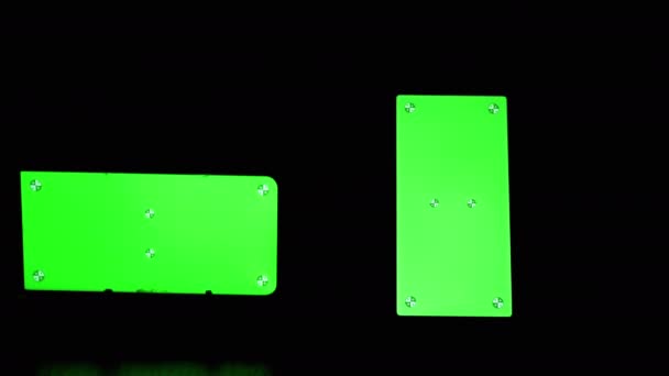 검은 연기 속에 서 있는 녹색 화면이 달린 스마트폰의 실루엣 — 비디오