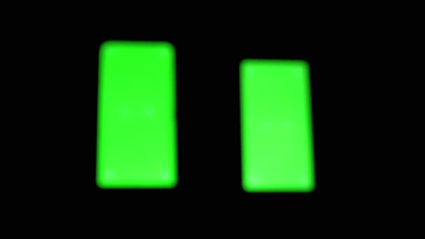 Два смартфона с зеленым экраном, хрома, маркеры на черном фоне. Zoom — стоковое видео