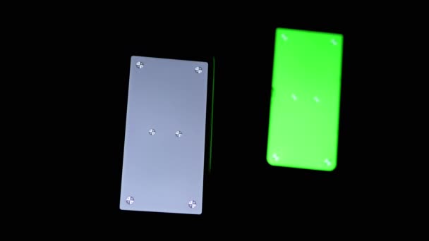 Два смартфони з зеленим, сірим екраном, хрома, маркери на чорному фоні — стокове відео