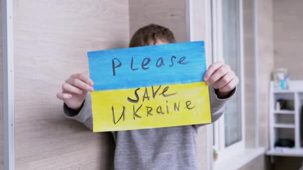 Dítě drží prapor s modrou a žlutou vlajkou, Zpráva Please Save Ukraine — Stock video