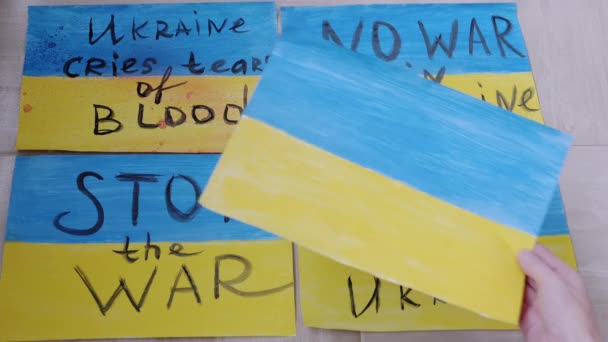 Γυναικεία χέρια απλώστε σχέδια στο πάτωμα με επιγραφές Σταματήστε τον πόλεμο στην Ουκρανία — Αρχείο Βίντεο