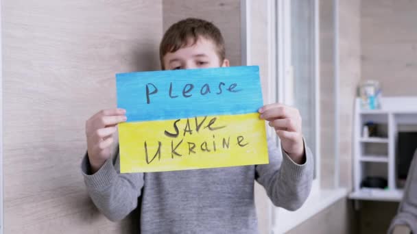 Dítě drží prapor s modrou a žlutou vlajkou, Zpráva Please Save Ukraine — Stock video