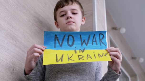 Παιδί κρατά στα χέρια ένα πανό με μια σημαία της Ουκρανίας, και το μήνυμα δεν υπάρχει πόλεμος — Αρχείο Βίντεο