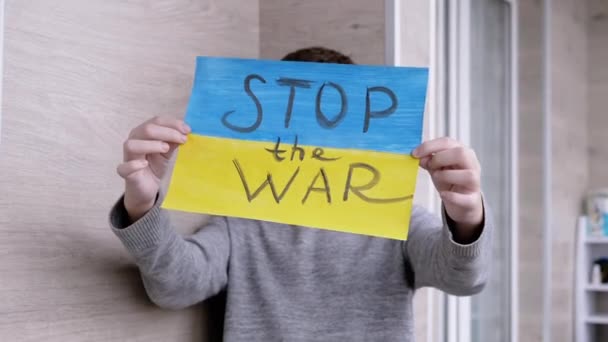 Dítě drží v ruce plakát s vlajkou Ukrajiny, a zpráva zastavit válku — Stock video
