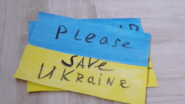 女性の手は、ウクライナで戦争を停止碑文と床の上に図面をレイアウト — ストック動画