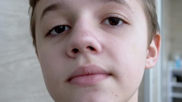 Primer plano de la cara de un niño sonriente, con hermosos ojos, mirando a la cámara — Vídeos de Stock
