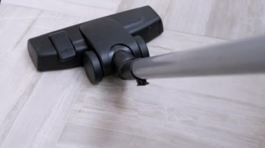 Bir süpürge fırçası odadaki döşeme üzerindeki çöpü temizler.