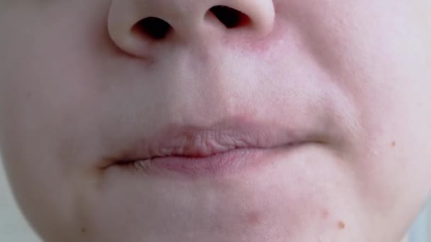 Lustiges Porträt eines lächelnden Kindes, das sich die Lippen leckt. Nahaufnahme — Stockvideo
