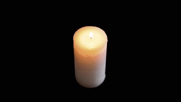 Eine weiße große brennende Kerze auf schwarzem Hintergrund. Ansicht von oben. — Stockvideo