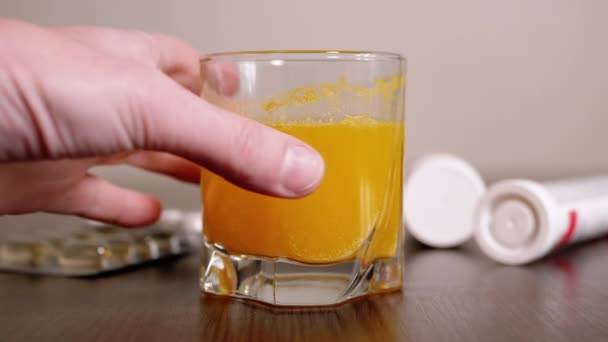 Femme tend la main vers un verre avec une tablette effervescente dissoute. 4K — Video