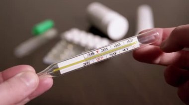 Kadın Elleri Yüksek Vücut Sıcaklığına sahip Cam Cıva Termometresi Tutuyor