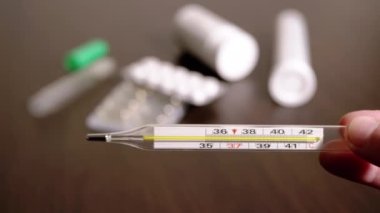 Kadın Elleri Yüksek Vücut Sıcaklığına sahip Cam Cıva Termometresi Tutuyor