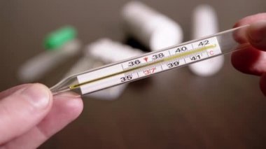 Kadın Elleri Yüksek Vücut Sıcaklığına sahip Cam Cıva Termometresi Tutuyor